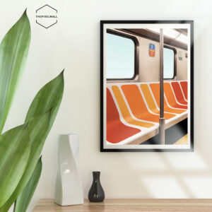 An empty subway car with vibrant orange and red striped seats. Sunlight streams in through the window, casting a warm glow on the interior.